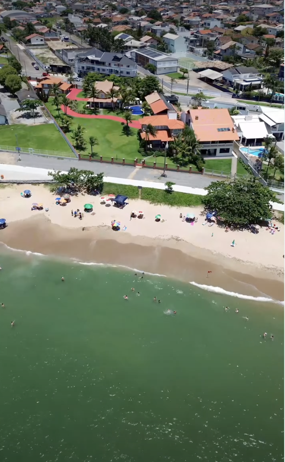 Vista aérea das casas à beira-mar e do calçadão da Praia do Quilombo